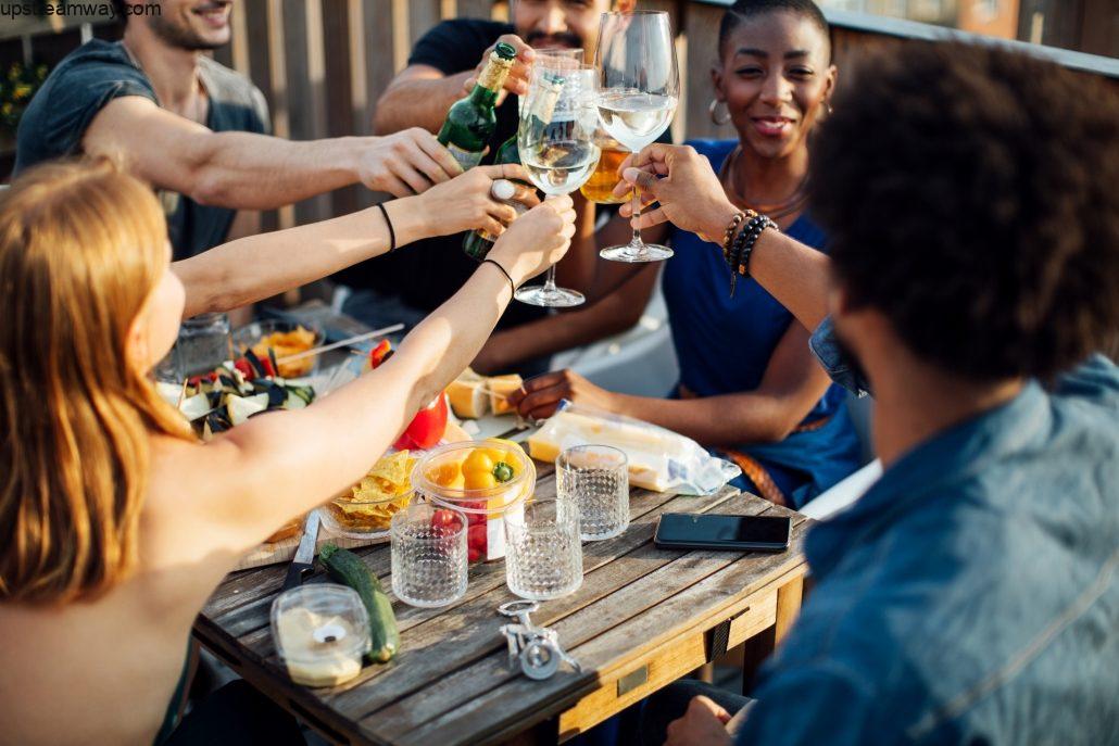 Friends enjoying party with alcoholic drinks at rooftop