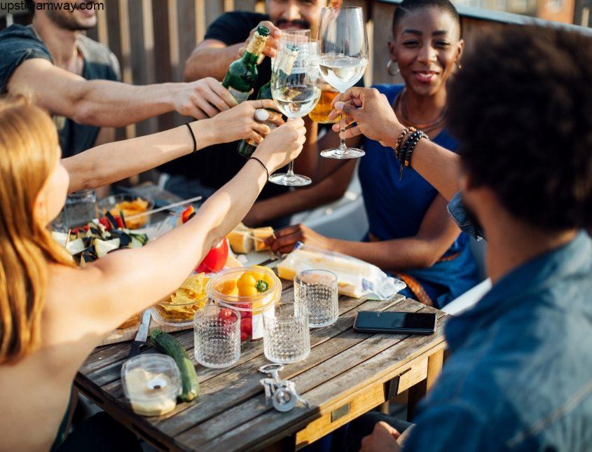 Friends enjoying party with alcoholic drinks at rooftop