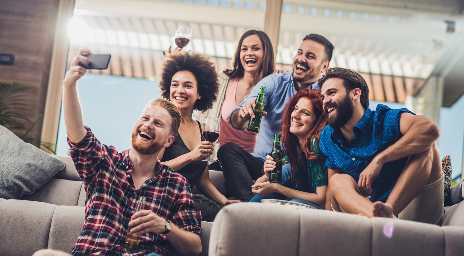Happy friends having fun while taking a selfie on a home party.